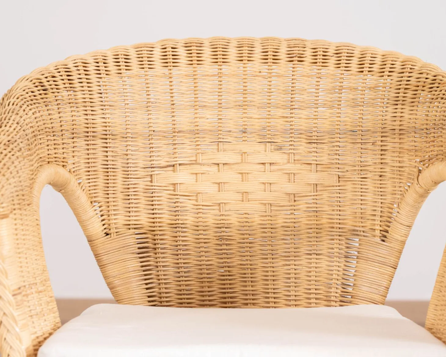 Elégant petit fauteuil en rotin tressé avec assise tissu "Noho"