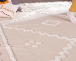 Tapis beige tissé main et motifs brodés blancs 