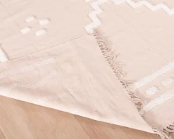 Tapis beige tissé main et motifs brodés blancs 